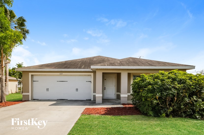 A house with a garage and a driveway in front of it.