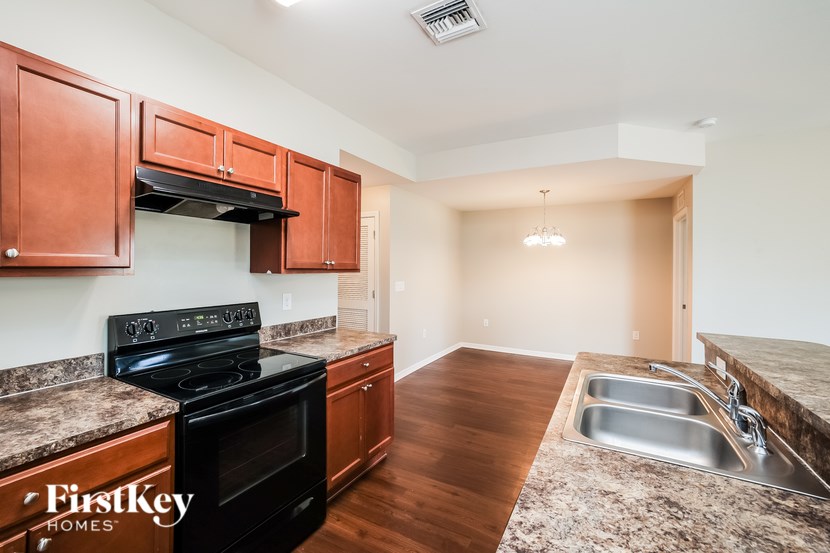 A kitchen with wooden cabinets and a black stove top oven.