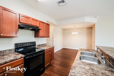 A kitchen with wooden cabinets and a black stove top oven.