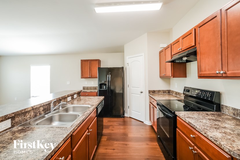 A kitchen with wooden cabinets and a black stove top oven.