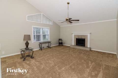 A living room with a fireplace and a fan.