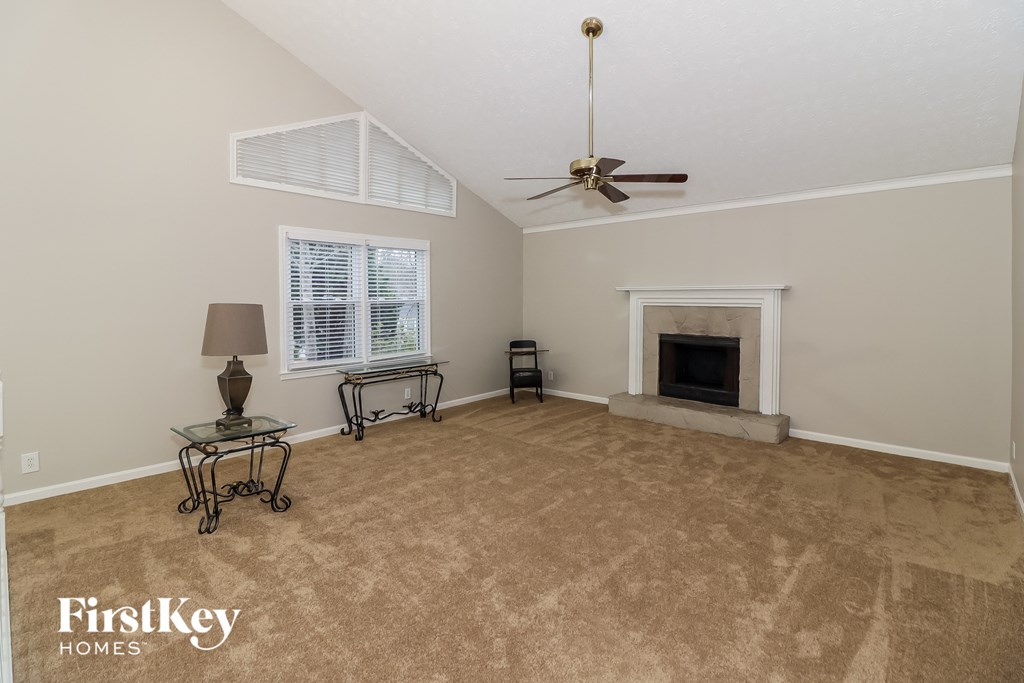 A living room with a fireplace and a fan.