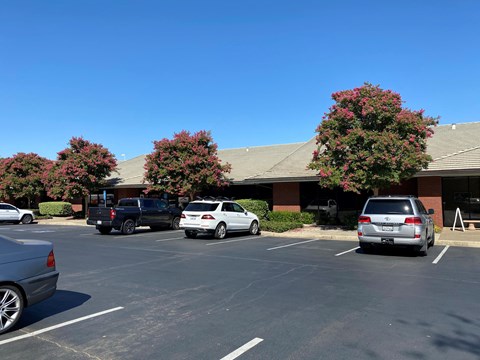 a parking lot with cars in front of a building