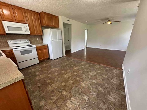A kitchen with brown cabinets and a white refrigerator.