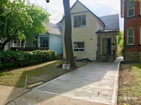 a white house with a sidewalk in front of it