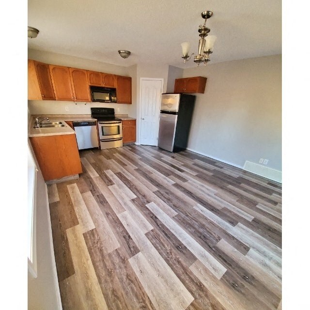 a kitchen with wood flooring in an empty room