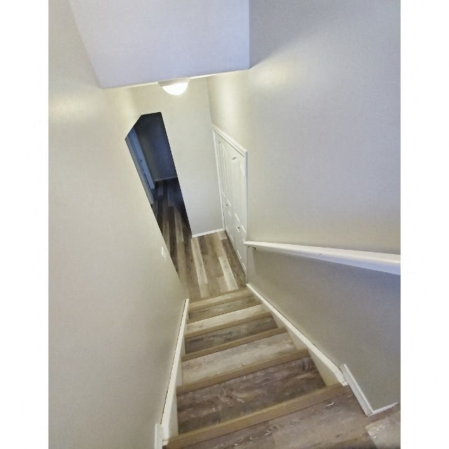 a stairwell with wooden floors and white walls