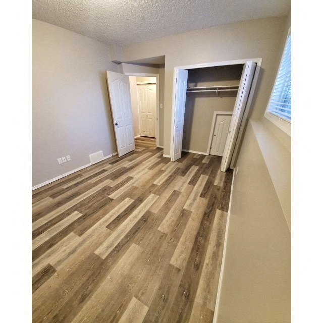 a hallway with wood flooring and a closet