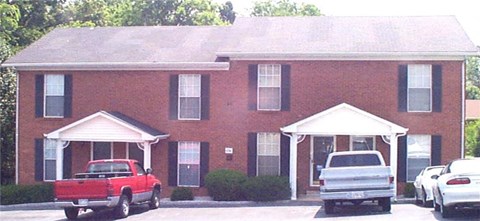 A red truck is parked in front of a house.