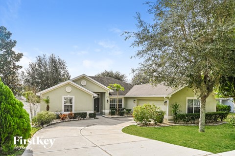 a house with a driveway and a tree
