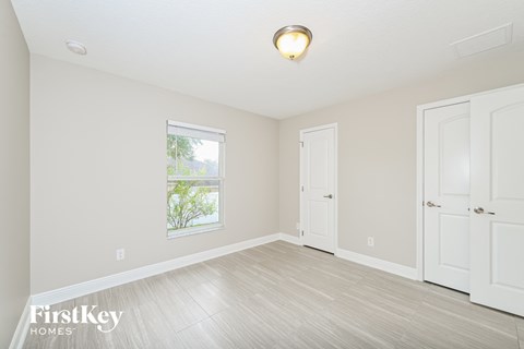 a bedroom with white walls and white doors and a window