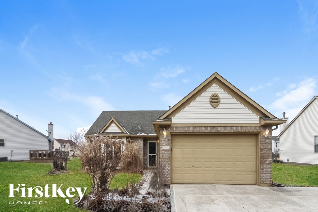 A house with a garage door and a sign that says "FirstKey HOME".