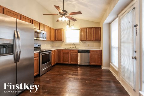 A kitchen with wooden cabinets and a stainless steel refrigerator.