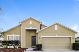 a beige house with a garage door and a driveway