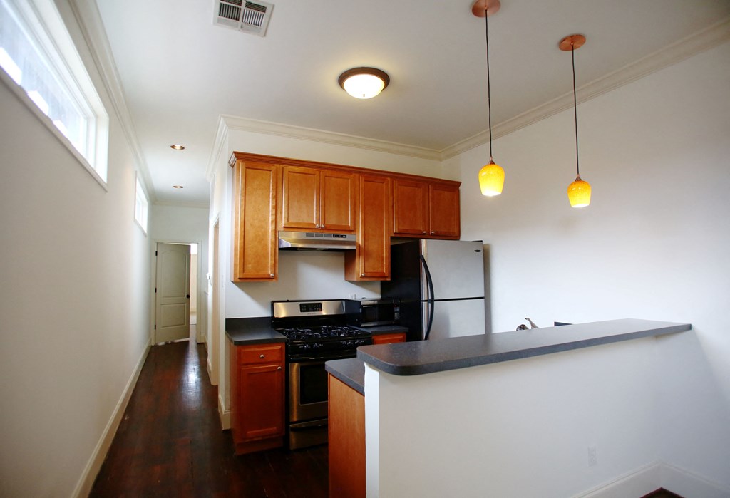 a kitchen with wooden cabinets and a black counter top