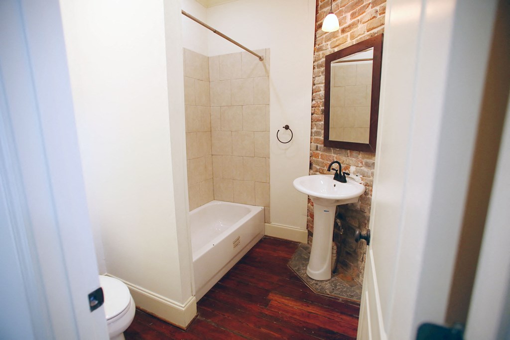 a small bathroom with a tub and a sink and a mirror