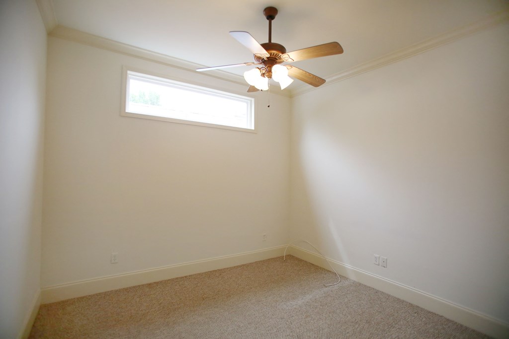a empty room with a ceiling fan and a window