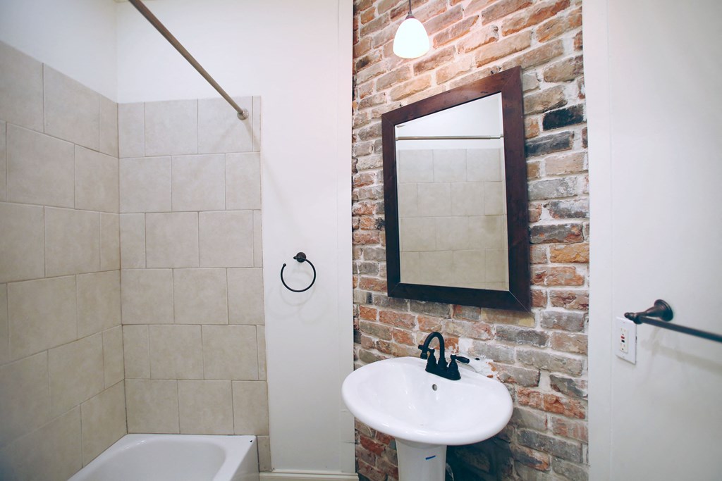 a bathroom with a sink and a shower and a mirror