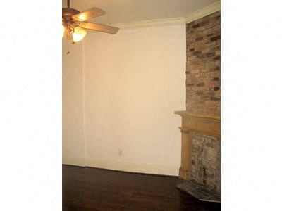a living room with a fireplace and a ceiling fan