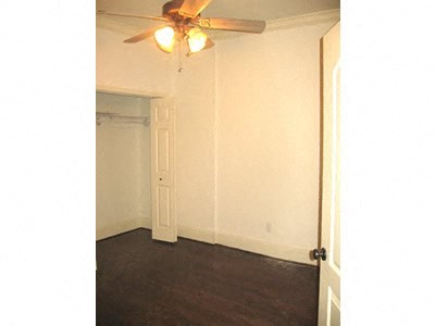 an empty bedroom with a ceiling fan and a door