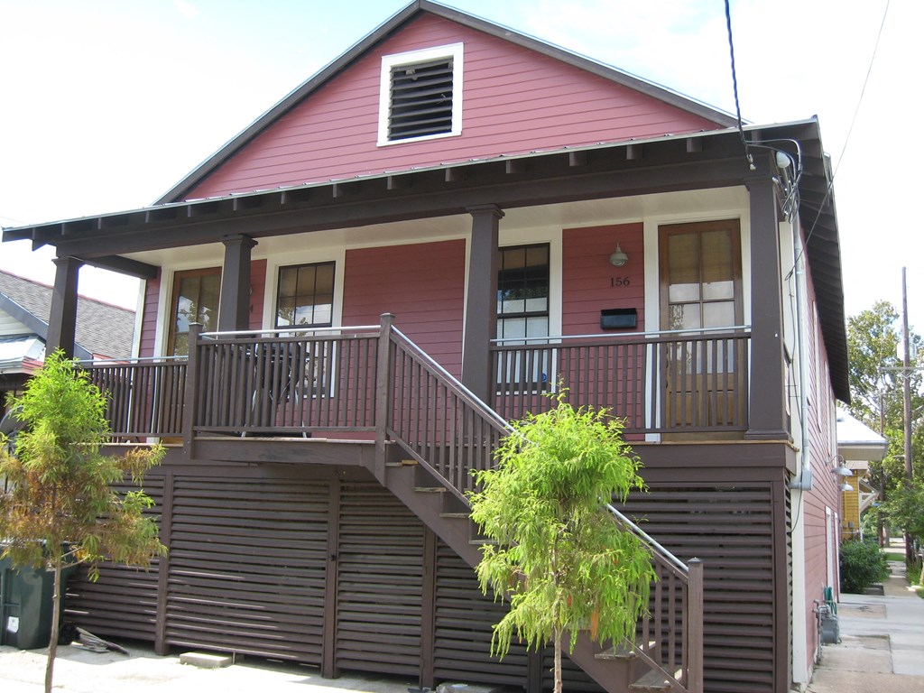 a red house with a porch and a staircase