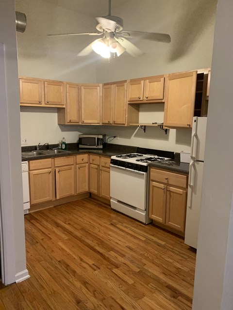 an empty kitchen with wooden floors and wooden cabinets