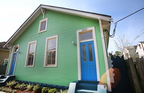 A green house with a blue door and a number 1822 on the front.