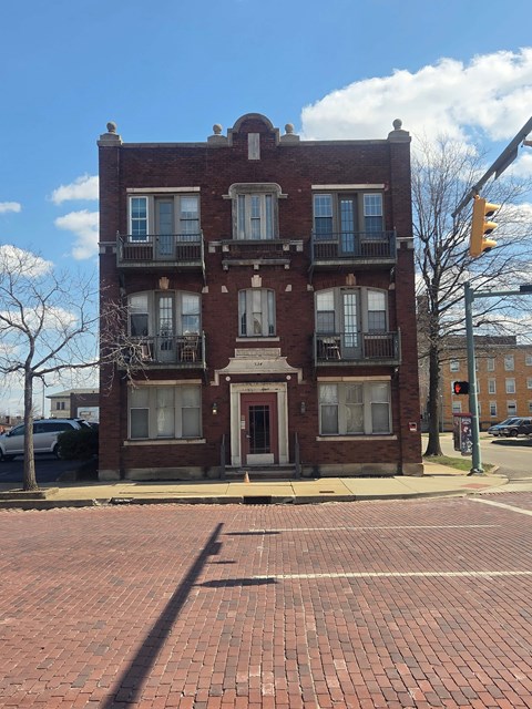 A red brick building with a balcony on the second floor.