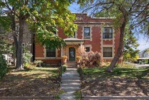 a brick house with a sidewalk in front of it