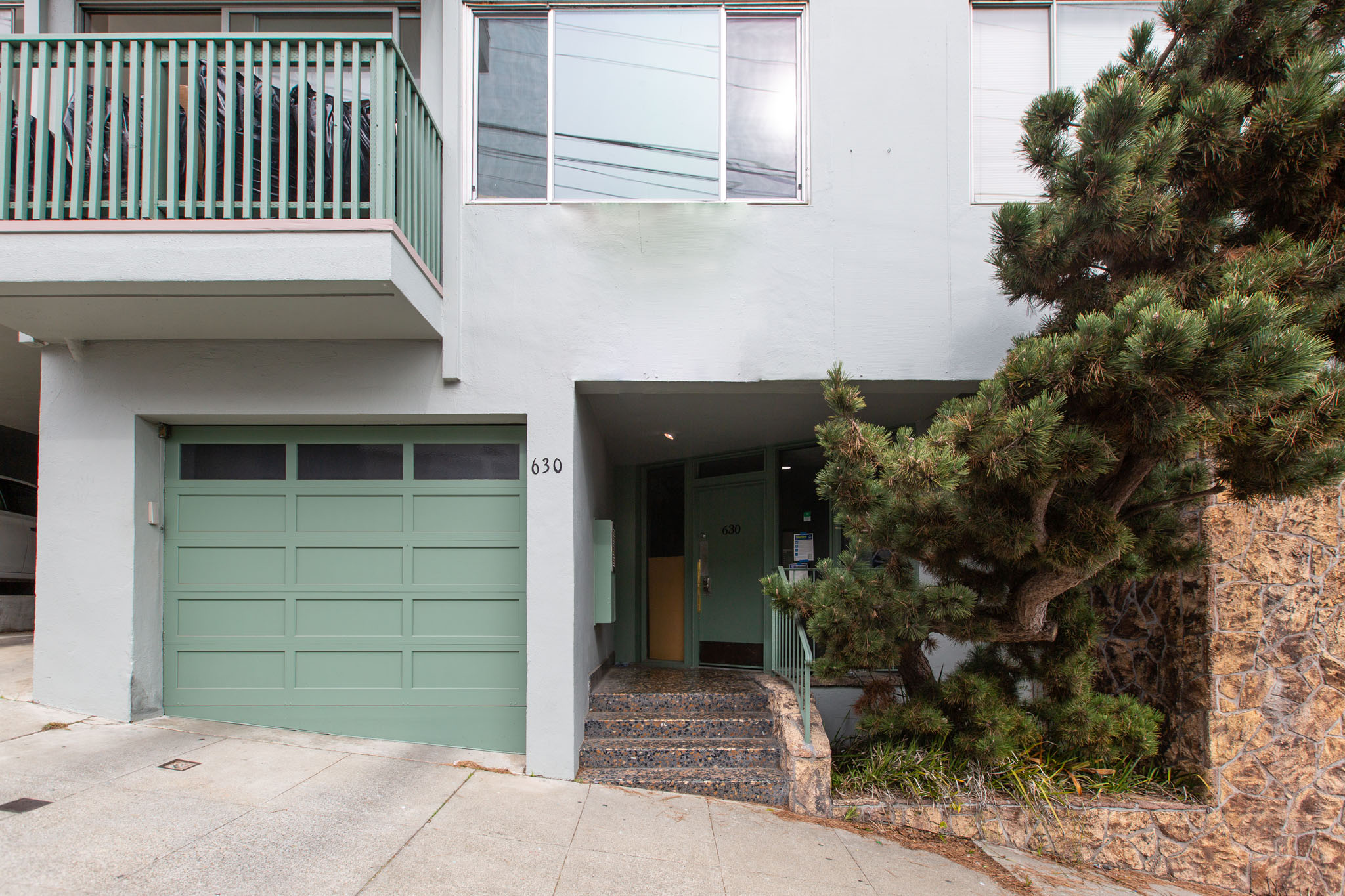 A white building with a green garage door.