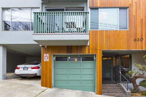 A car is parked in a garage under a sign that says "No Parking".