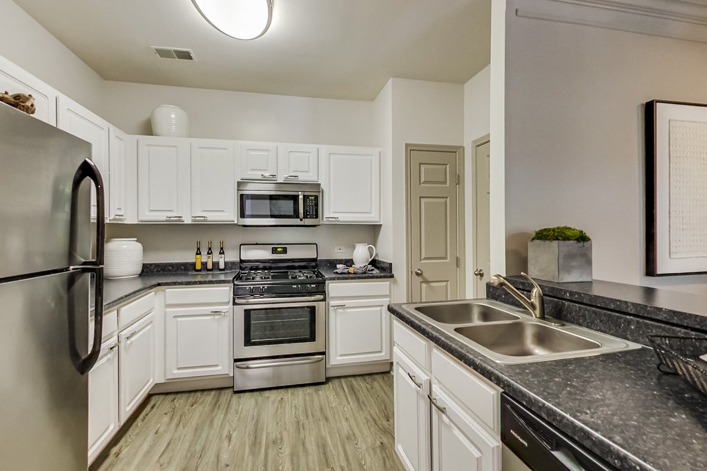 the preserve at ballantyne commons apartment kitchen with stainless steel appliances and white cabinets