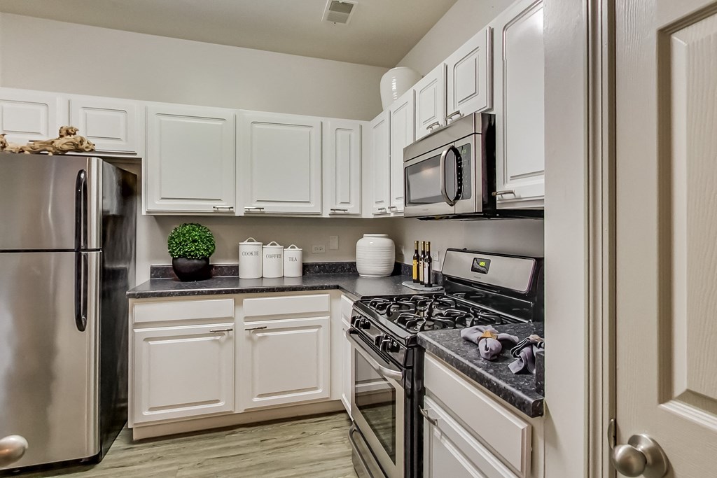 a kitchen with stainless steel appliances and white cabinets