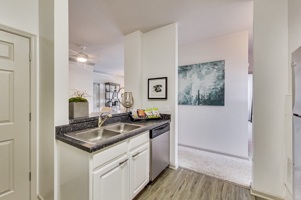 a kitchen with white cabinets and a stainless steel sink