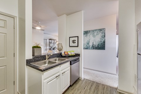a kitchen with white cabinets and a stainless steel sink