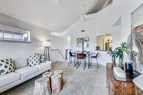 a living room with a white couch and a dining room table