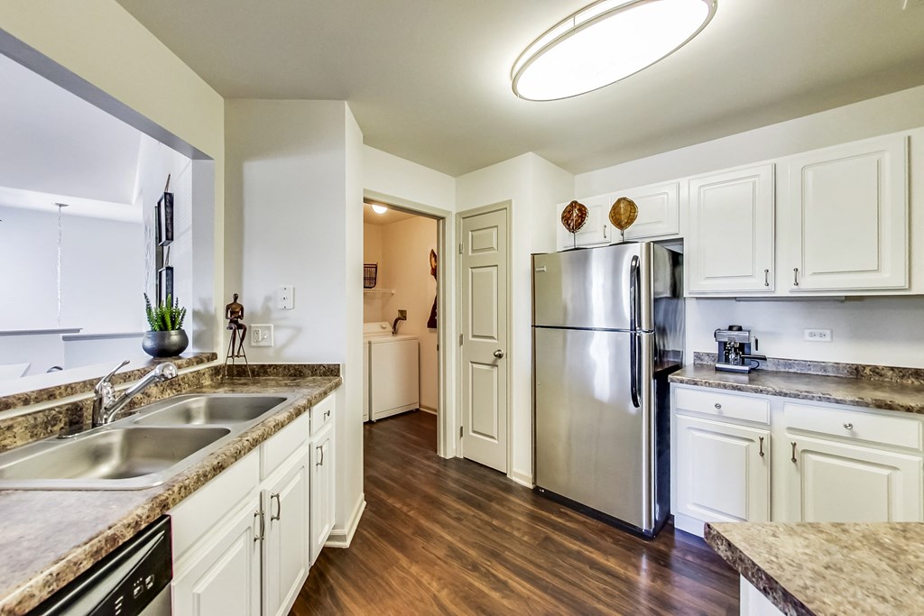 a kitchen with white cabinets and a stainless steel refrigerator