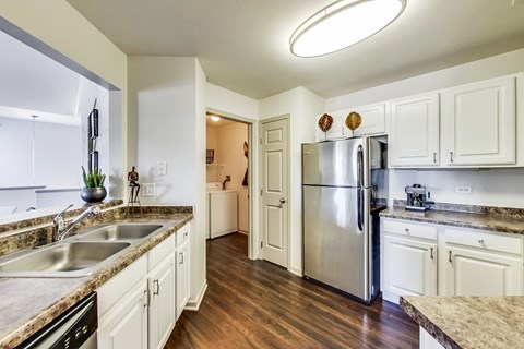 a kitchen with white cabinets and a stainless steel refrigerator