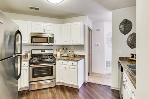 a kitchen with stainless steel appliances and white cabinets