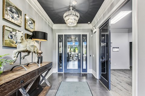 a hallway with a horse statue and a chandelier
