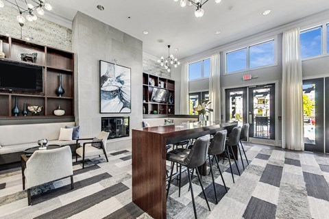 a living room with a bar and a dining room with chairs