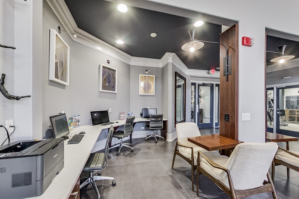 a computer room with desks and chairs and a computer monitor