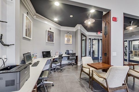 a computer room with desks and chairs and a computer monitor