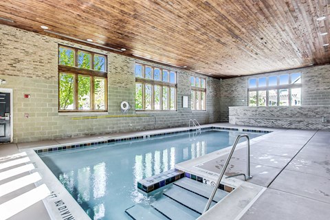 a swimming pool with a wooden ceiling and brick walls