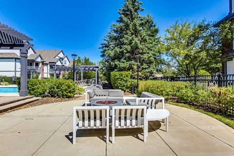 an outdoor patio with chairs and tables and a pool