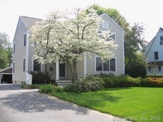 a white flowering tree in front of a house