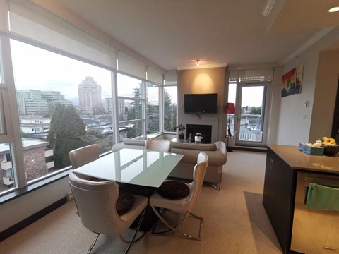 a living room with a table and chairs and a large window