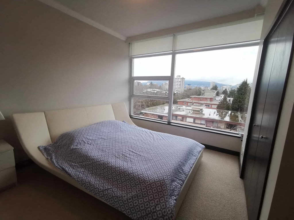a bedroom with a bed and a large window
