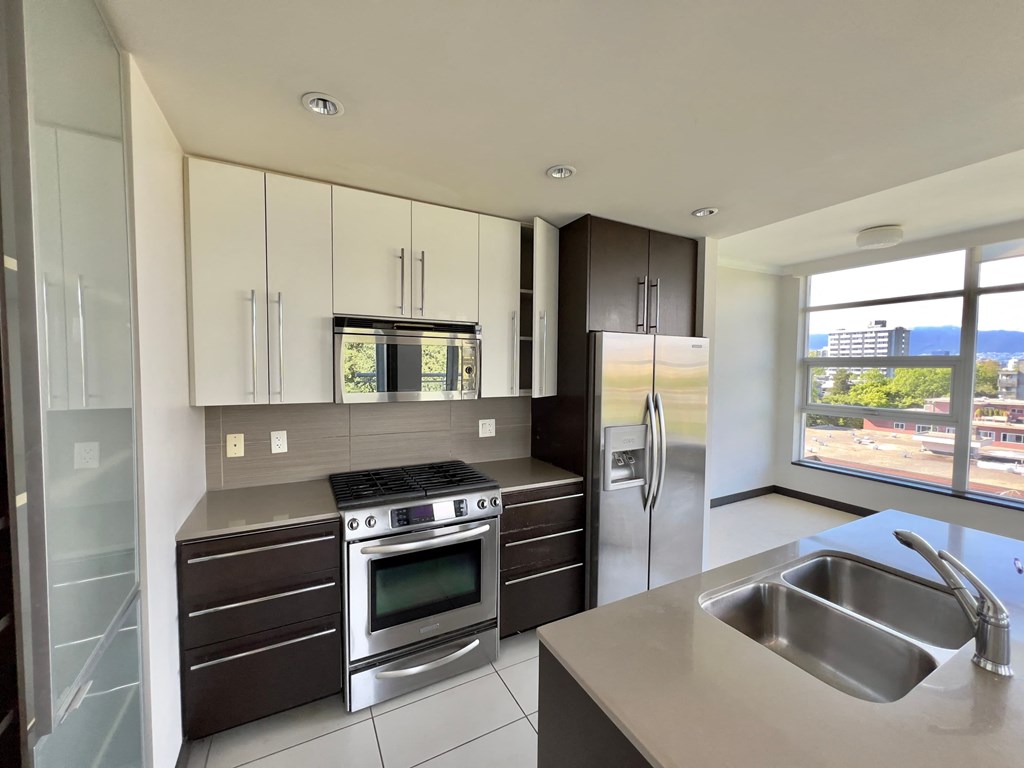 a modern kitchen with stainless steel appliances and white cabinets