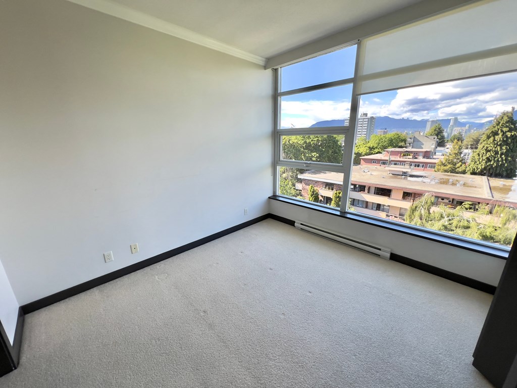 an empty room with a large window and a view of the city